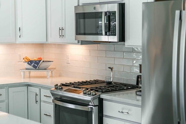 kitchen with decorative backsplash, light countertops, and stainless steel appliances