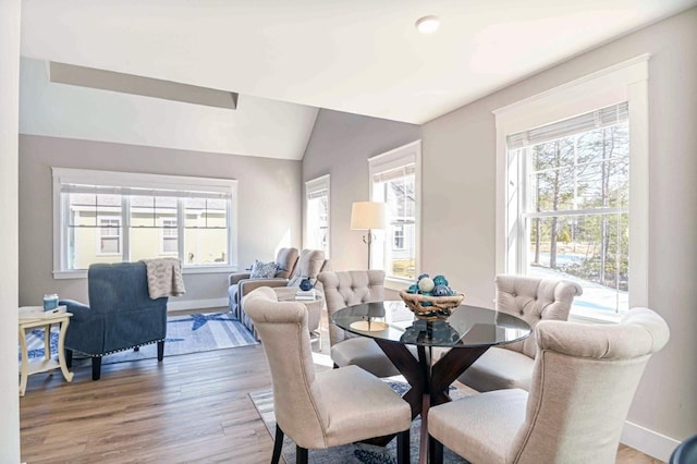 dining area with lofted ceiling, a wealth of natural light, baseboards, and light wood finished floors