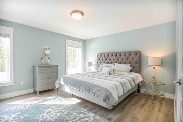 bedroom with baseboards and wood finished floors