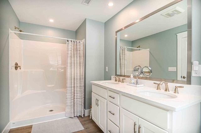 bathroom featuring curtained shower, visible vents, and a sink