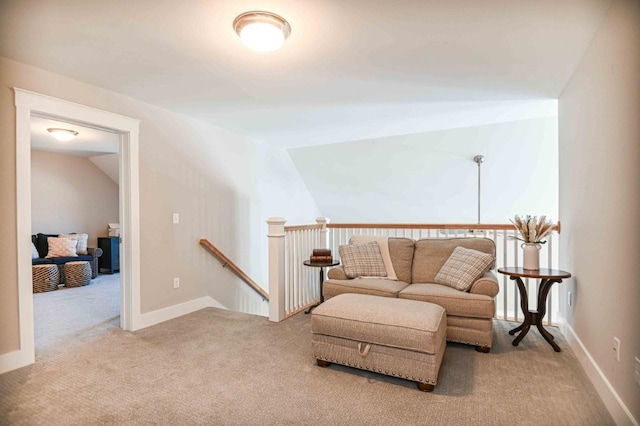 sitting room featuring baseboards, an upstairs landing, lofted ceiling, and carpet flooring