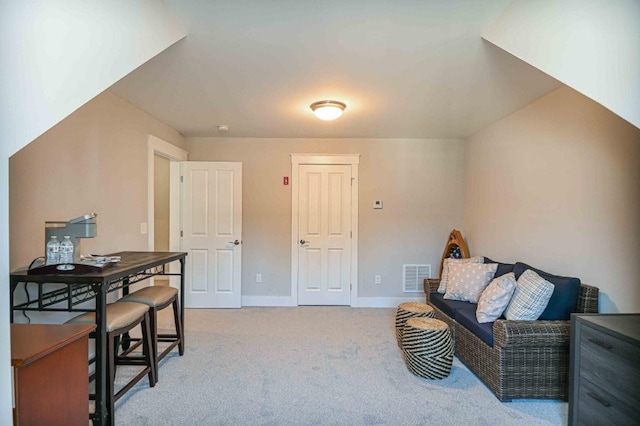 sitting room with light colored carpet, visible vents, and baseboards