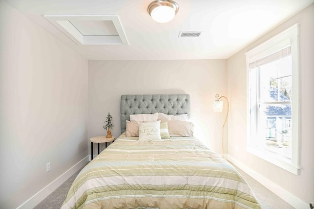 carpeted bedroom featuring attic access, baseboards, and visible vents