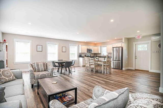 living area with recessed lighting, light wood-style flooring, and baseboards