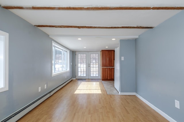 empty room with baseboards, light wood finished floors, beam ceiling, french doors, and baseboard heating