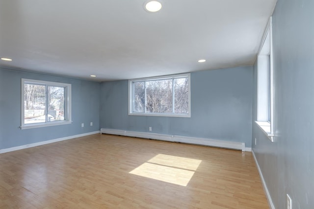 spare room with recessed lighting, light wood-style floors, baseboards, and baseboard heating