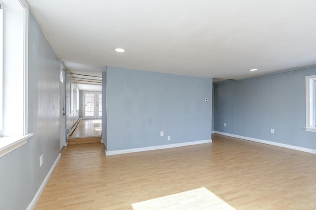 unfurnished room with recessed lighting, light wood-style floors, baseboards, and french doors