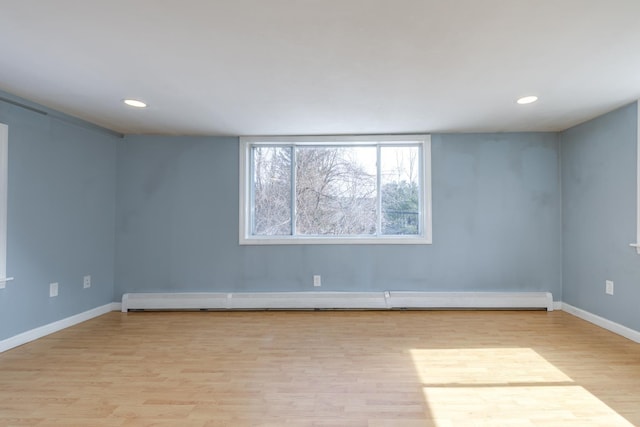 unfurnished room with recessed lighting, baseboards, light wood finished floors, and a baseboard radiator