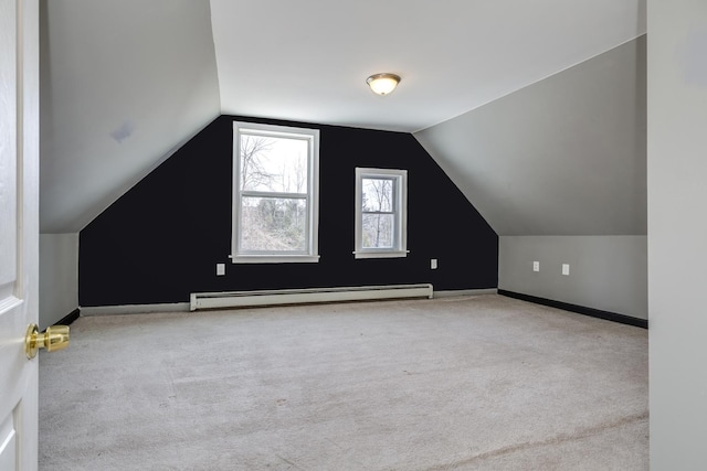 additional living space with baseboards, a baseboard heating unit, lofted ceiling, and carpet floors