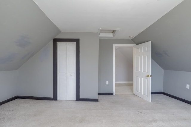 bonus room with light carpet, attic access, baseboards, and vaulted ceiling