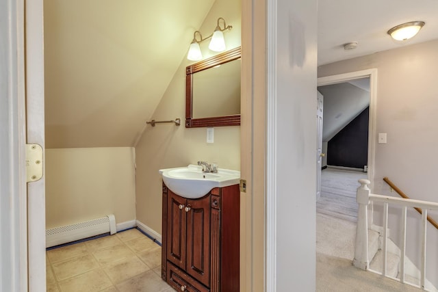 bathroom with baseboard heating, vanity, baseboards, and vaulted ceiling