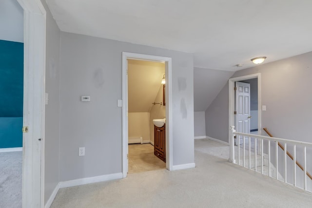 additional living space featuring a baseboard heating unit, carpet floors, lofted ceiling, and baseboards