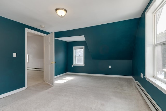 additional living space featuring vaulted ceiling, carpet floors, baseboards, and a baseboard radiator