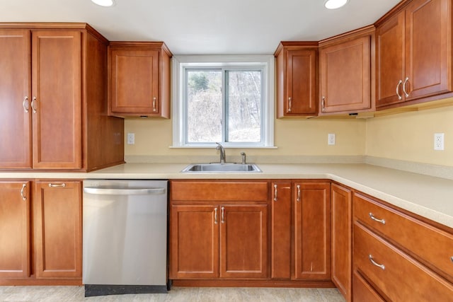 kitchen featuring dishwasher, light countertops, brown cabinets, and a sink