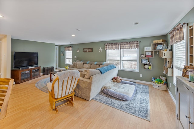 living room with recessed lighting, baseboards, a healthy amount of sunlight, and wood finished floors