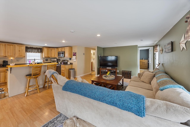 living room featuring recessed lighting, light wood-style floors, and baseboards