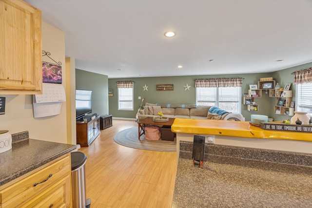 living room with plenty of natural light, recessed lighting, light wood-type flooring, and baseboards