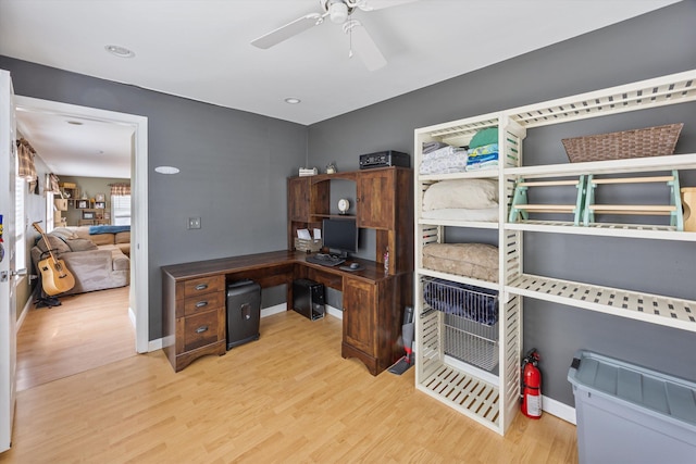 office featuring baseboards, light wood-style floors, and a ceiling fan