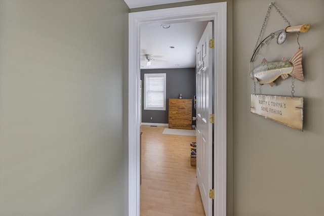 hall with baseboards and light wood-style floors