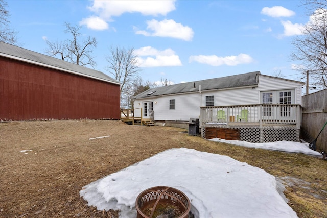 rear view of house with french doors, fence, and a wooden deck