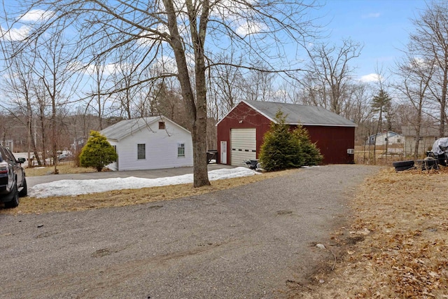 exterior space featuring a garage and an outbuilding