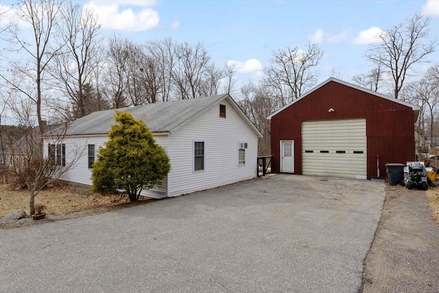 view of property exterior with a garage and an outbuilding