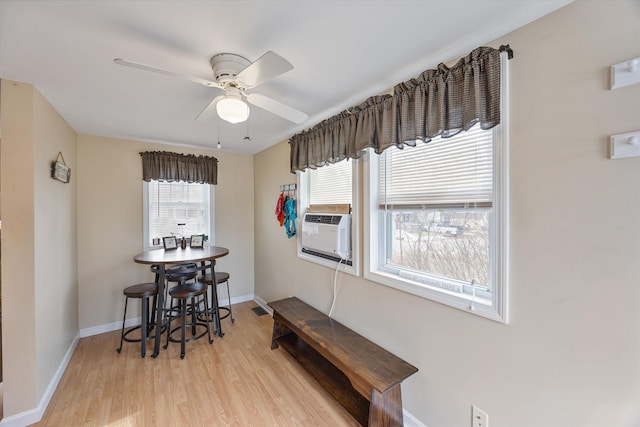 dining area featuring cooling unit, a ceiling fan, light wood-type flooring, and baseboards