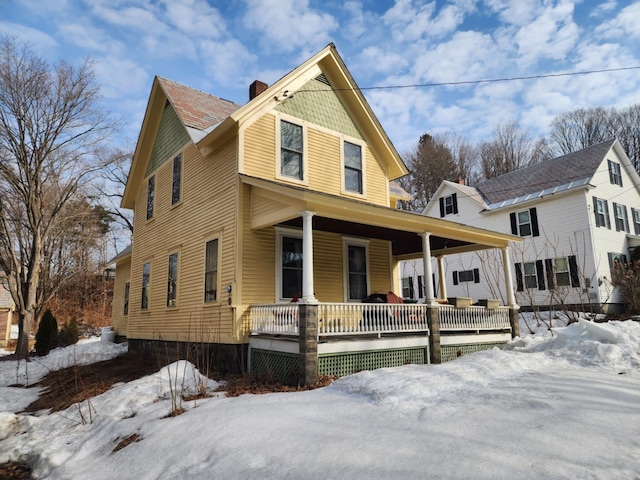 view of front of house featuring covered porch and a chimney