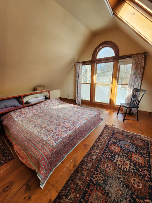 bedroom featuring lofted ceiling and baseboards