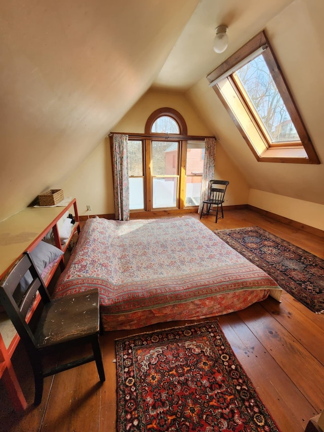 unfurnished bedroom featuring baseboards, lofted ceiling, and hardwood / wood-style floors