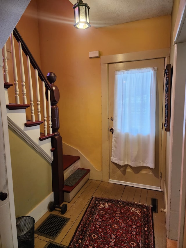 entrance foyer with a textured ceiling and hardwood / wood-style flooring