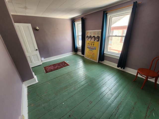 unfurnished room featuring baseboards and wood-type flooring