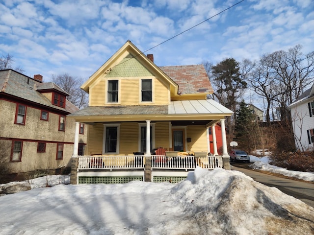 view of front of property with covered porch and a chimney