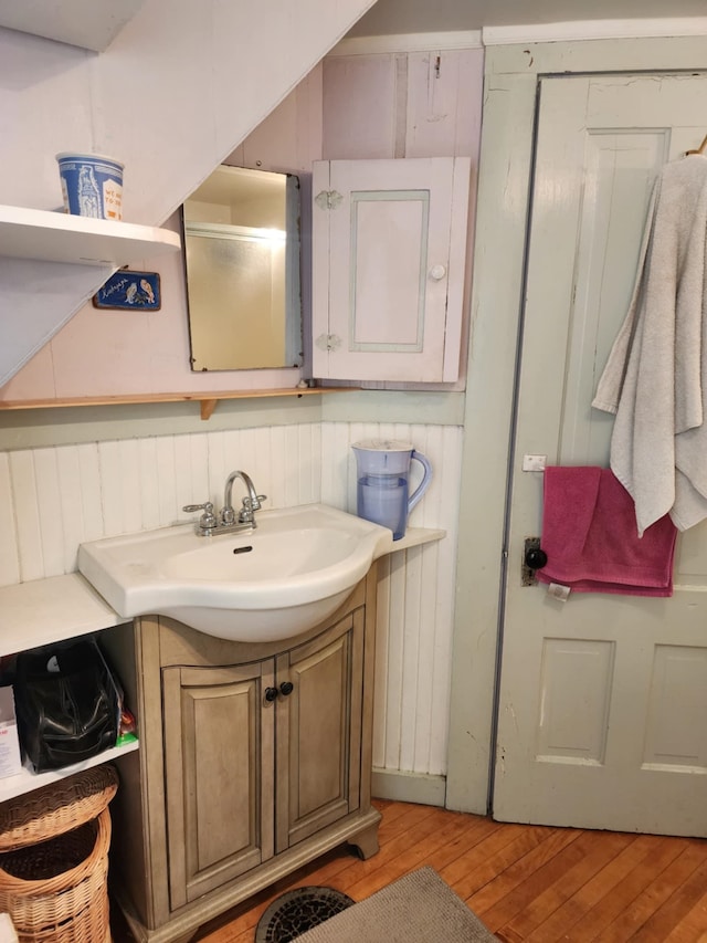 bathroom with electric panel, vanity, and wood-type flooring