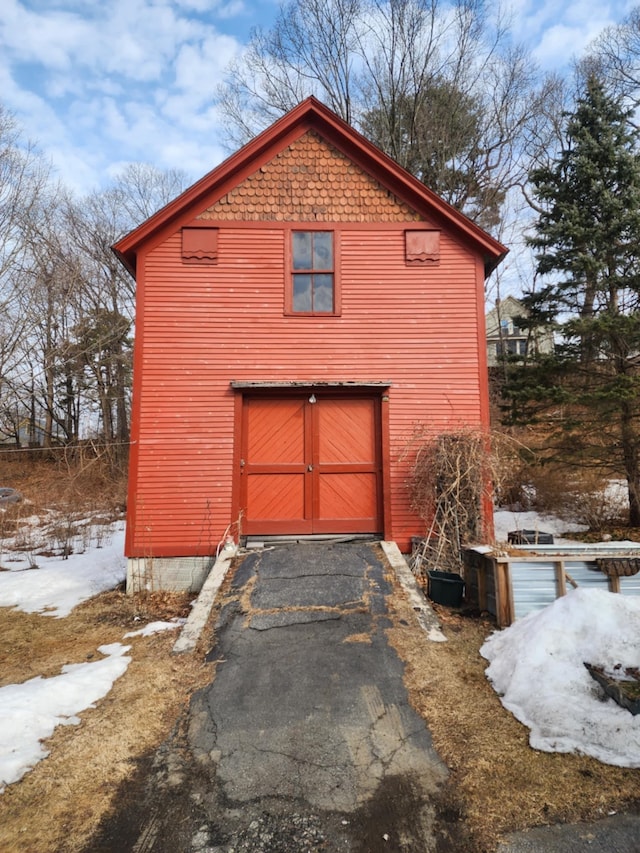 snow covered garage with driveway