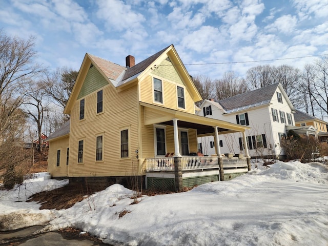 exterior space featuring covered porch and a chimney