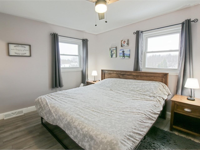 bedroom featuring dark wood-style floors, baseboards, visible vents, and ceiling fan