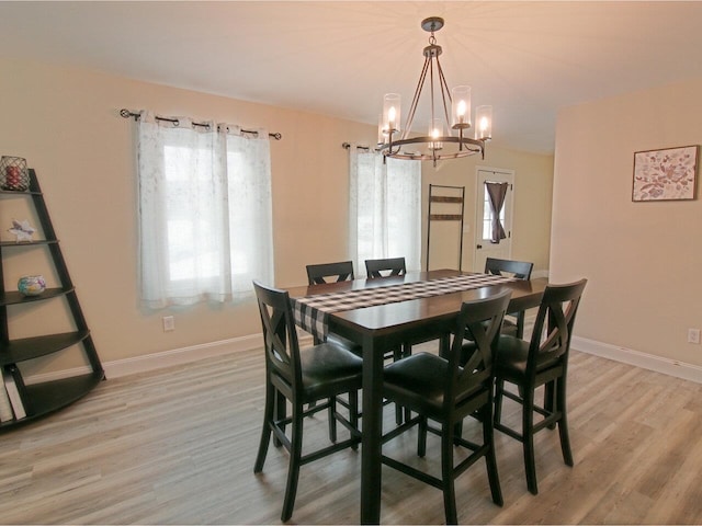 dining space featuring baseboards and light wood-style floors