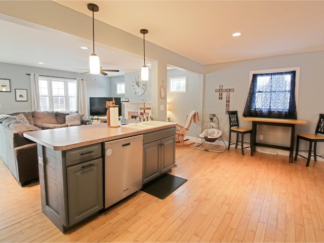 kitchen featuring dishwasher, light countertops, gray cabinets, and light wood-type flooring