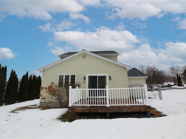 snow covered house featuring a wooden deck