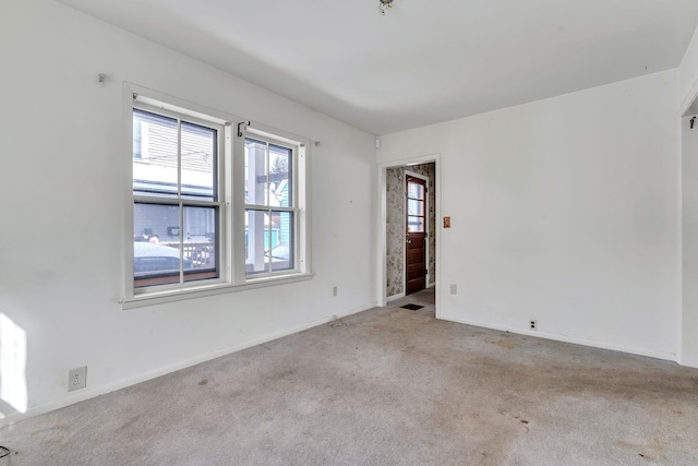 empty room featuring carpet flooring and baseboards