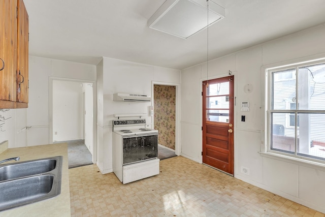 kitchen with a sink, range hood, white electric stove, light countertops, and light floors