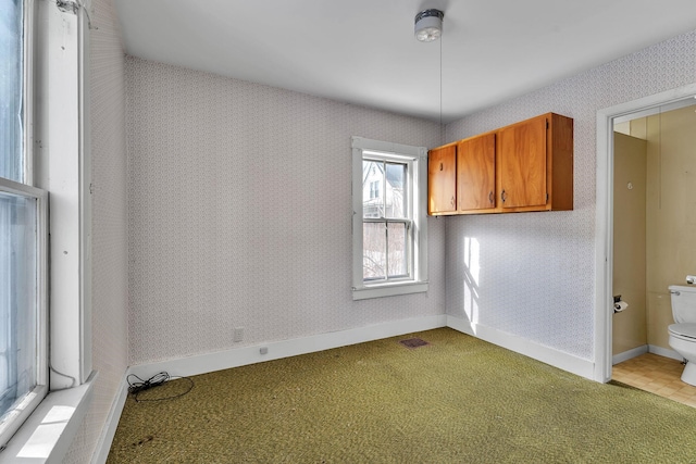 unfurnished room with wallpapered walls, baseboards, and light carpet