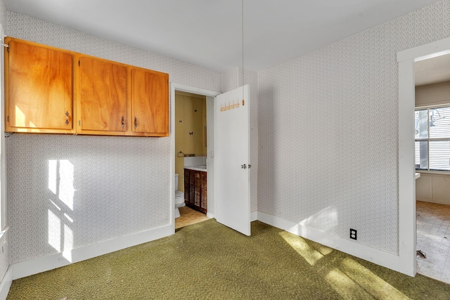 interior space featuring baseboards, carpet, and wallpapered walls