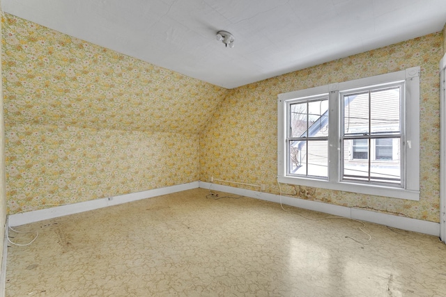 spare room with wallpapered walls and baseboards