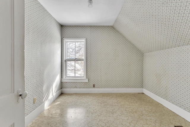 bonus room with wallpapered walls, lofted ceiling, and baseboards