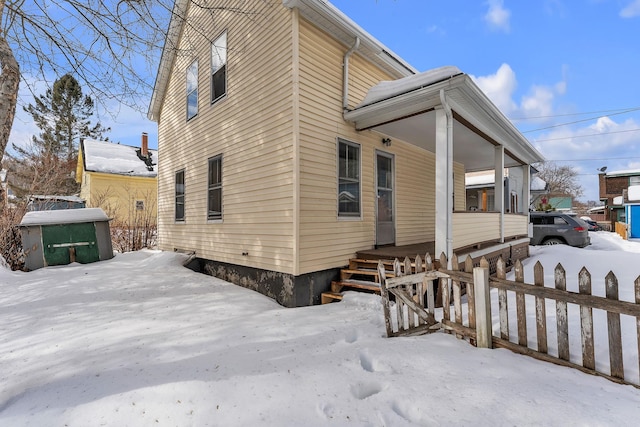 snow covered property with fence