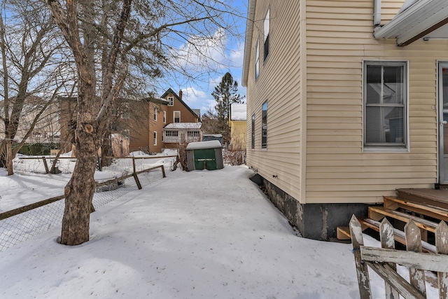 view of snowy exterior with fence