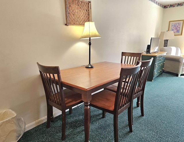 dining room featuring baseboards and dark colored carpet