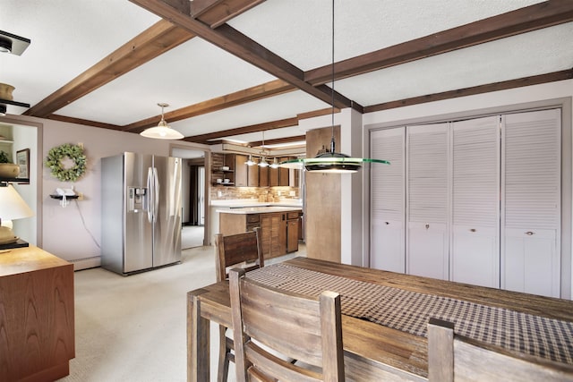 dining space featuring beam ceiling and light carpet